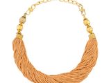 un collier orange orné de perles dorées sur fond blanc