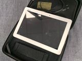 une mallette noire contenant une tablette, posée sur un lit