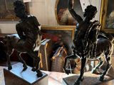 two statues of a man riding a horse and a woman riding a horse
