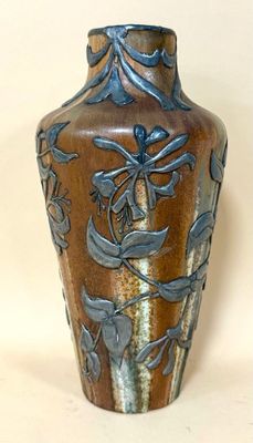 a brown vase with a blue design on it