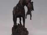 bronze statue of a horse and a dog standing on a rock