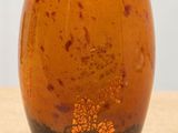 a brown vase sitting on top of a wooden table