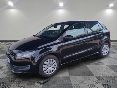 La Volkswagen Polo noire est garée dans une pièce dont le sol est en damier.