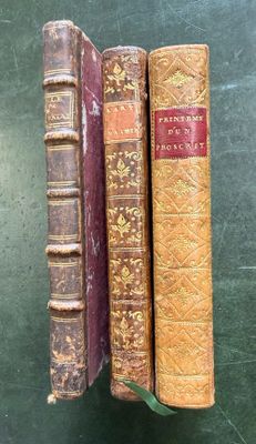 three old books sitting on top of each other on a table