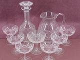 a group of wine glasses and a decanter on a table