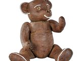 un ours en peluche marron assis par terre