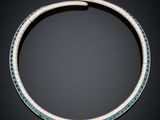 a necklace with turquoise and white stones on a black background