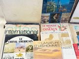 several books are sitting on a table in front of a window