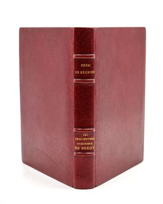a red book with gold lettering sitting on top of a white surface