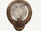 a mirror that has a candle in it on a wall