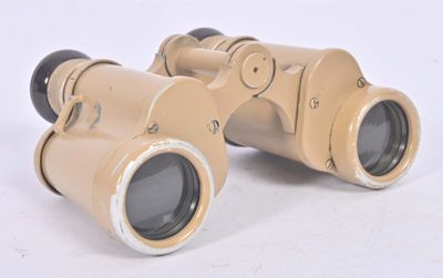 an old pair of binoculars sitting on top of a white surface