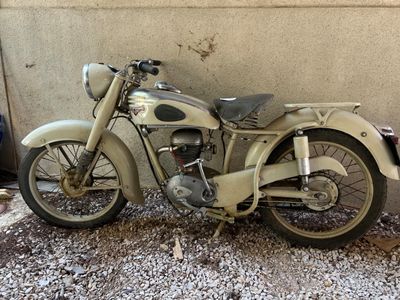 une vieille moto garée sur le gravier
