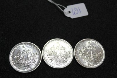 three silver coins sitting next to each other on a black surface