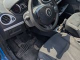 the interior of a blue car with its door open showing the driver ' s seat and steering wheel