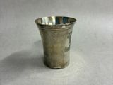 a small silver cup sitting on top of a white surface