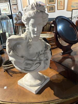 un buste de femme assise sur une table, avec un miroir