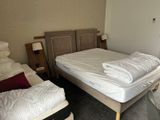 a bed with a white blanket on top of it in a room