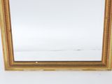 a gold framed mirror on a white surface with a white background