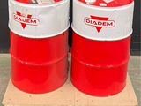 two red and white drums sitting on a pallet in front of a black wall