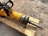 a yellow and black drill on a pallet on the ground