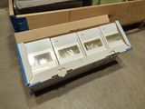 a box of empty boxes sitting on the floor next to a bed