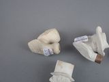 three pairs of white gloves and a hat on a gray surface