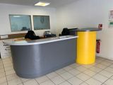 un espace d'accueil avec un comptoir jaune et gris