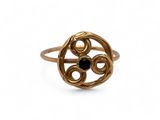 a close up of a gold ring with a black stone