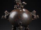 a large bronze vase with figures on top of it on a pedestal