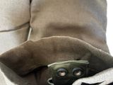 un gros plan d'une personne portant une veste avec un appareil photo dans la poche