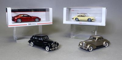Deux voitures miniatures sont exposées dans une vitrine posée sur une table.