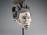 a close up of a sculpture of a head with horns on a stand