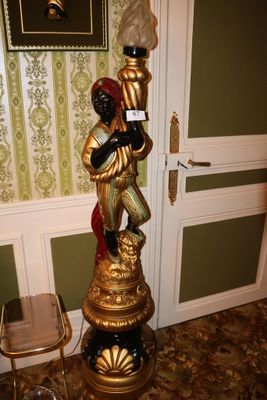 une statue représentant un homme tenant un verre de vin dans une pièce