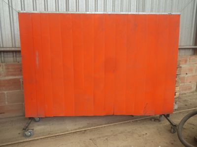 un gros plan sur un panneau orange monté sur roulettes devant un immeuble