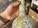 a person holding a vase in their hand in a store