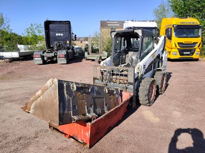 a tractor and a tractor trailer parked in a dirt lot