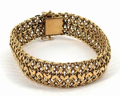gros plan d'un bracelet en or sur fond blanc