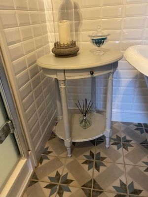 une petite table sur laquelle est posée une bougie, dans une salle de bains