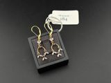 une paire de boucles d'oreilles en or et diamants dans un écrin noir