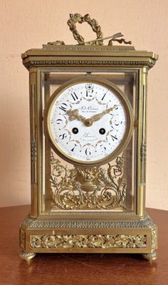 une horloge en or posée sur une table en bois