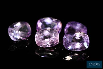 un groupe de trois pierres précieuses violettes posées sur une surface noire