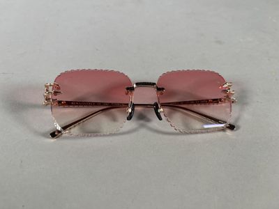 a close up of a pair of pink sunglasses on a white surface