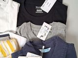 a lot of shirts that are sitting on a table