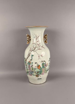 un vase blanc avec un tableau posé sur une table