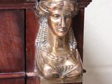 a statue of a woman that is on top of a cabinet
