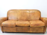 a brown leather couch sitting on the floor in a room