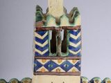 a ceramic figurine of a tower with a clock on it