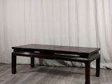 une table basse avec un tiroir, placée devant un rideau blanc