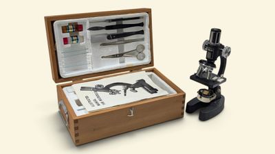 une boîte en bois contenant un microscope et d'autres objets