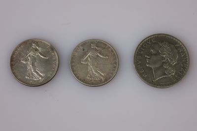trois pièces de monnaie britanniques posées côte à côte sur une surface blanche